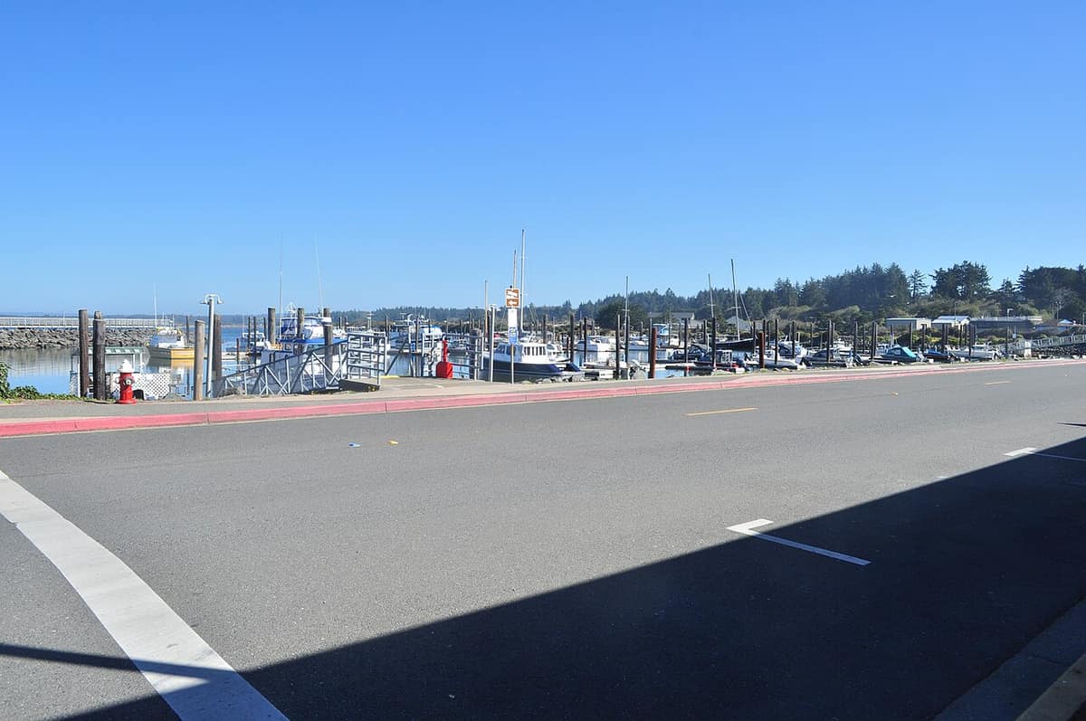 The Bandon boat basin with moored boats and a waterfront road in the foreground