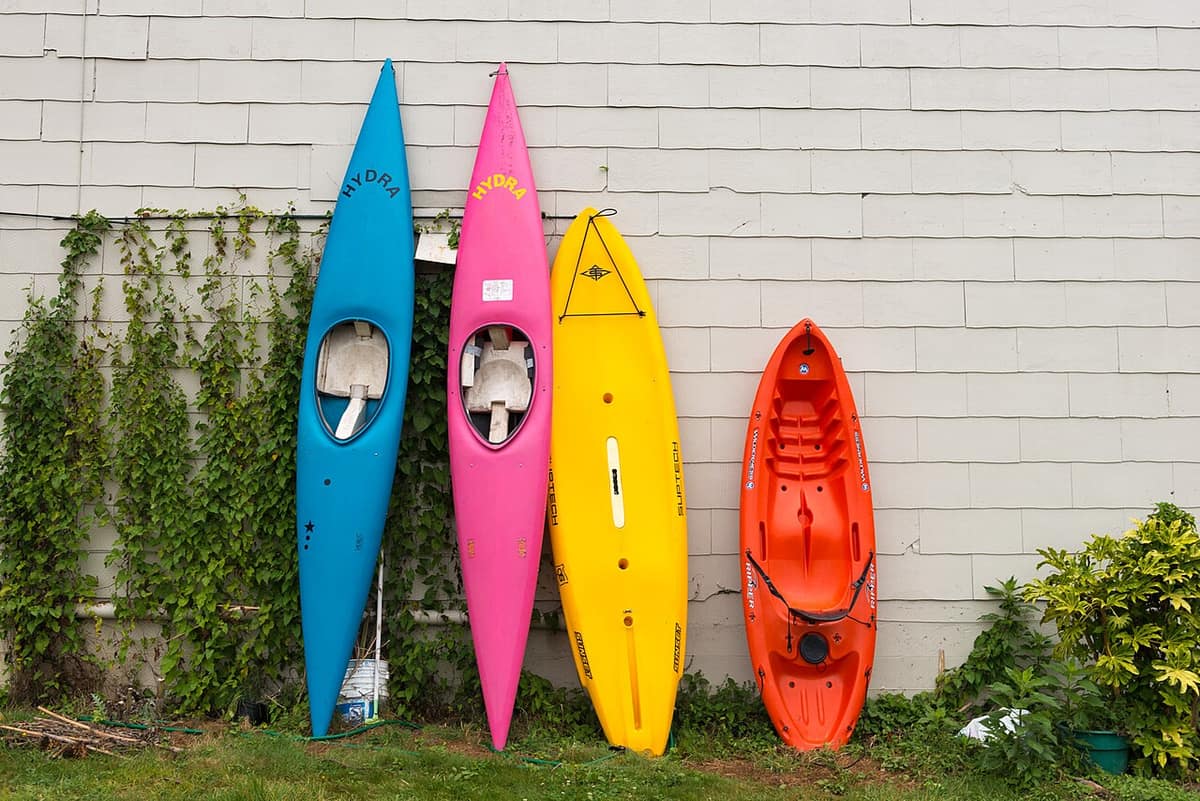 colorful kayaks leaning against a wall in downtown Brookings