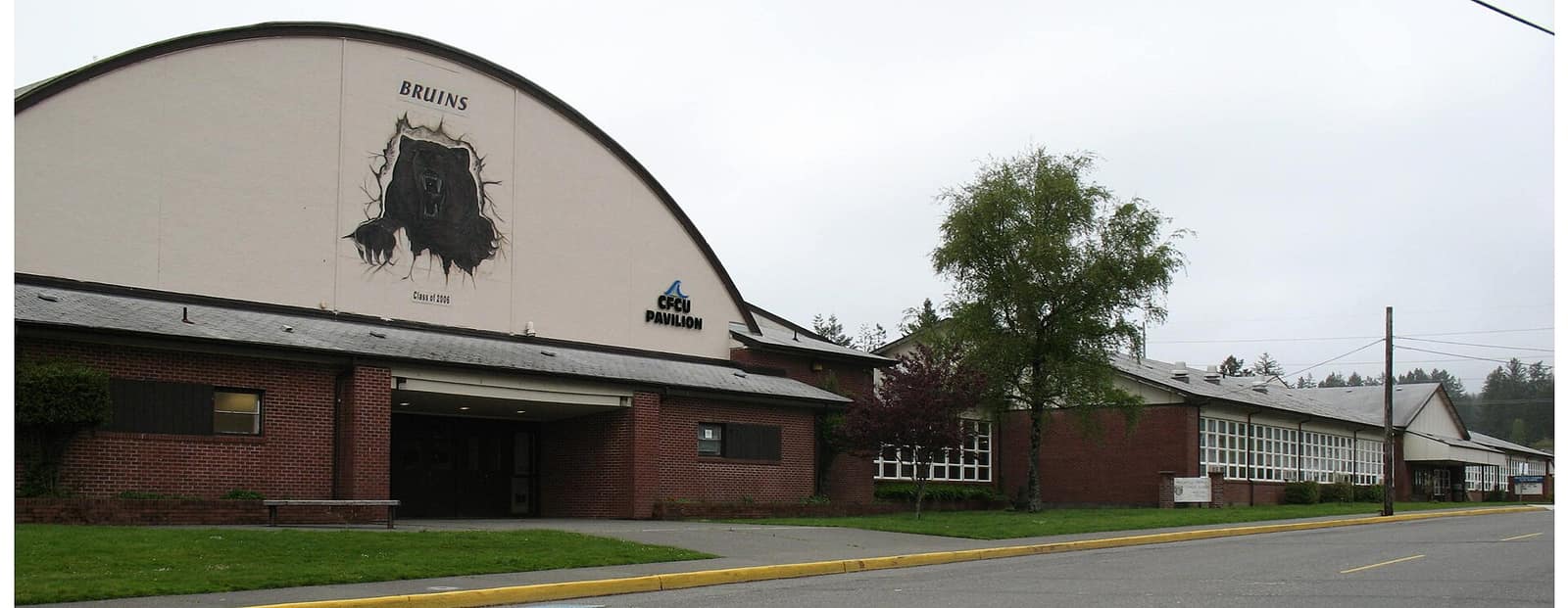 The Brookings-Harbor High School gymnasium and brick front of the school building along a street