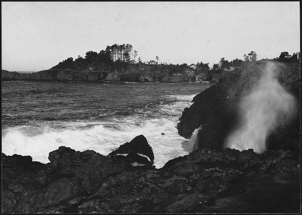 historic black-and-white photo of the Spouting Horn spraying through the lava rocks at Depoe Bay