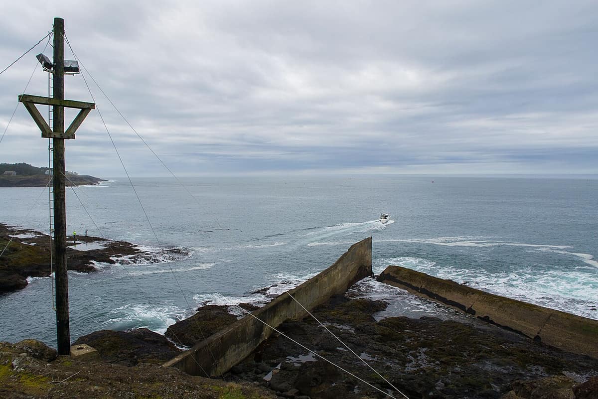 boat heading out from the Depoe Bay harbor channel into the Pacific