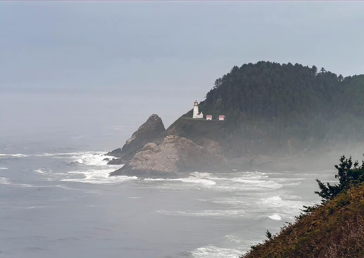 Heceta Head Lighthouse on its forested headland above the Pacific on a misty day