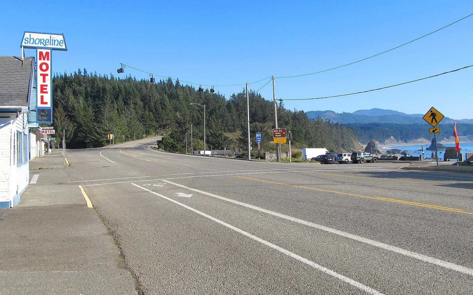 US 101 at Jefferson Street in Port Orford, with a motel on the left and the ocean and coastline visible at right