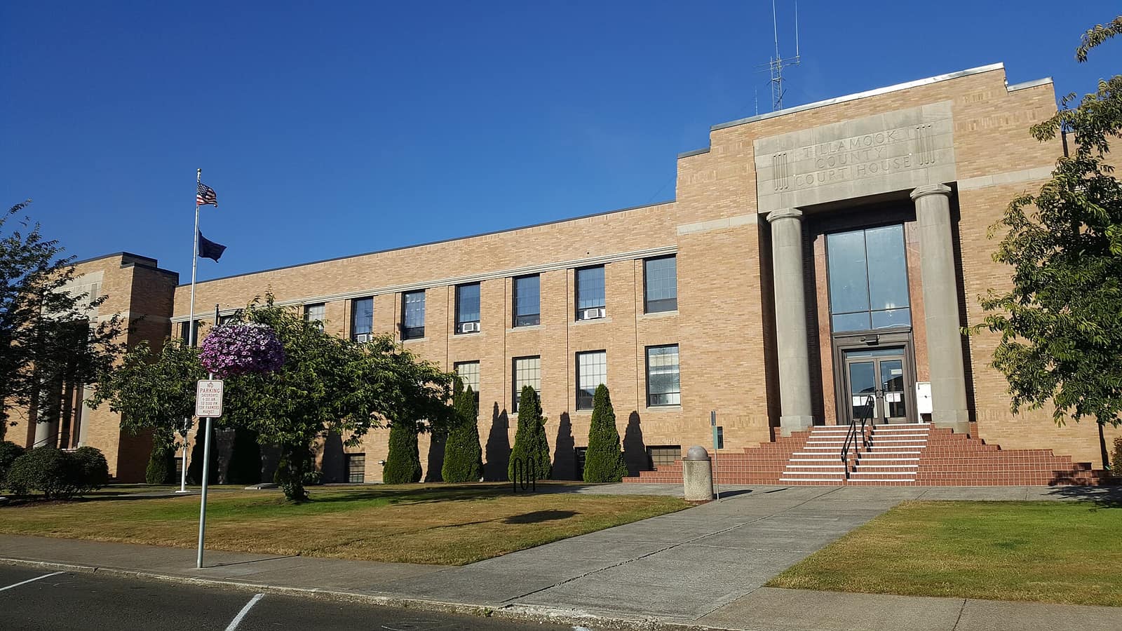 The Tillamook County Courthouse, a tan brick building with a columned entrance, on a clear day
